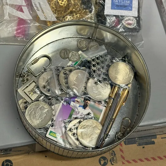 A cookie tin from the unit holding silver Peace dollars and Mercury dimes